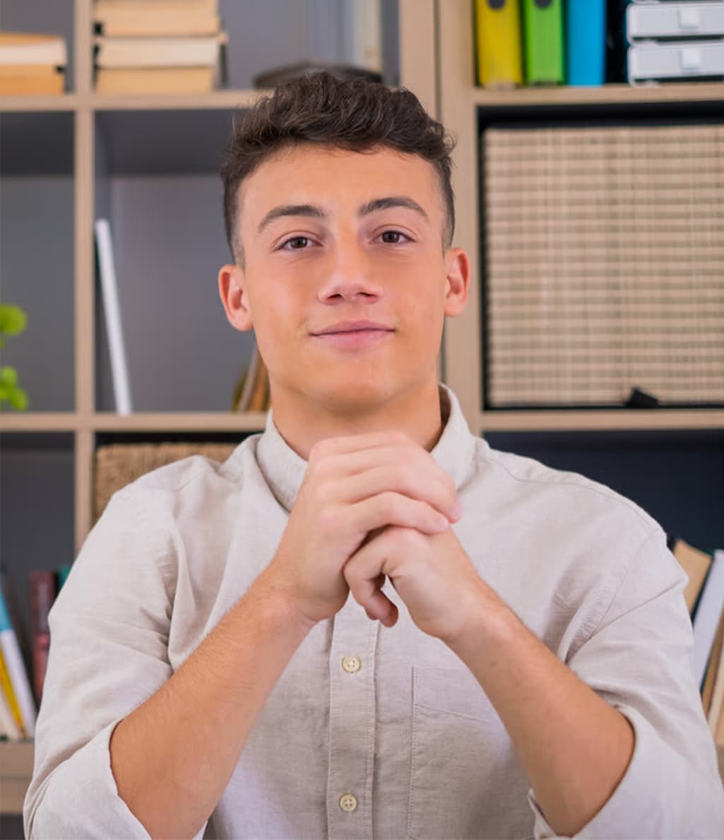 A young person sitting at a desk at home